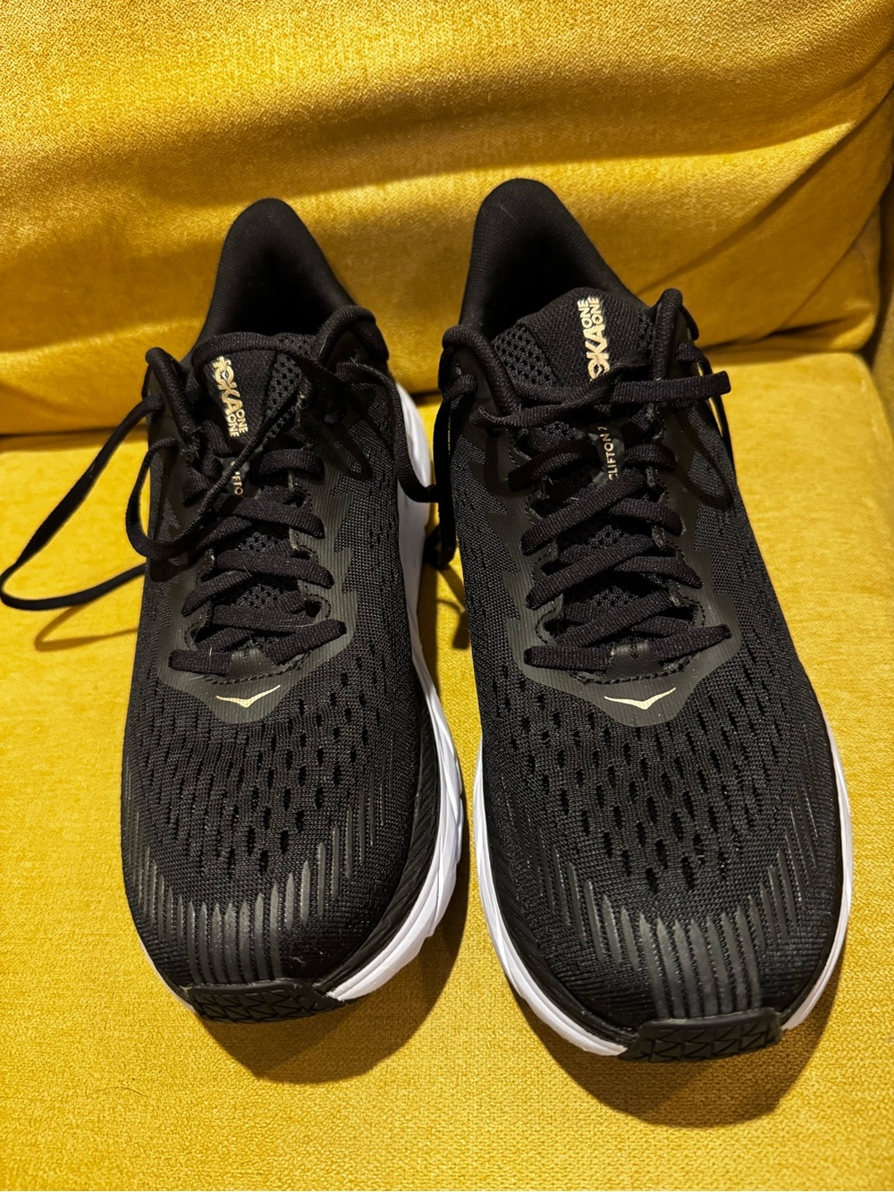 Hoka One One Black Running Shoes with White Soles and Gold Accents